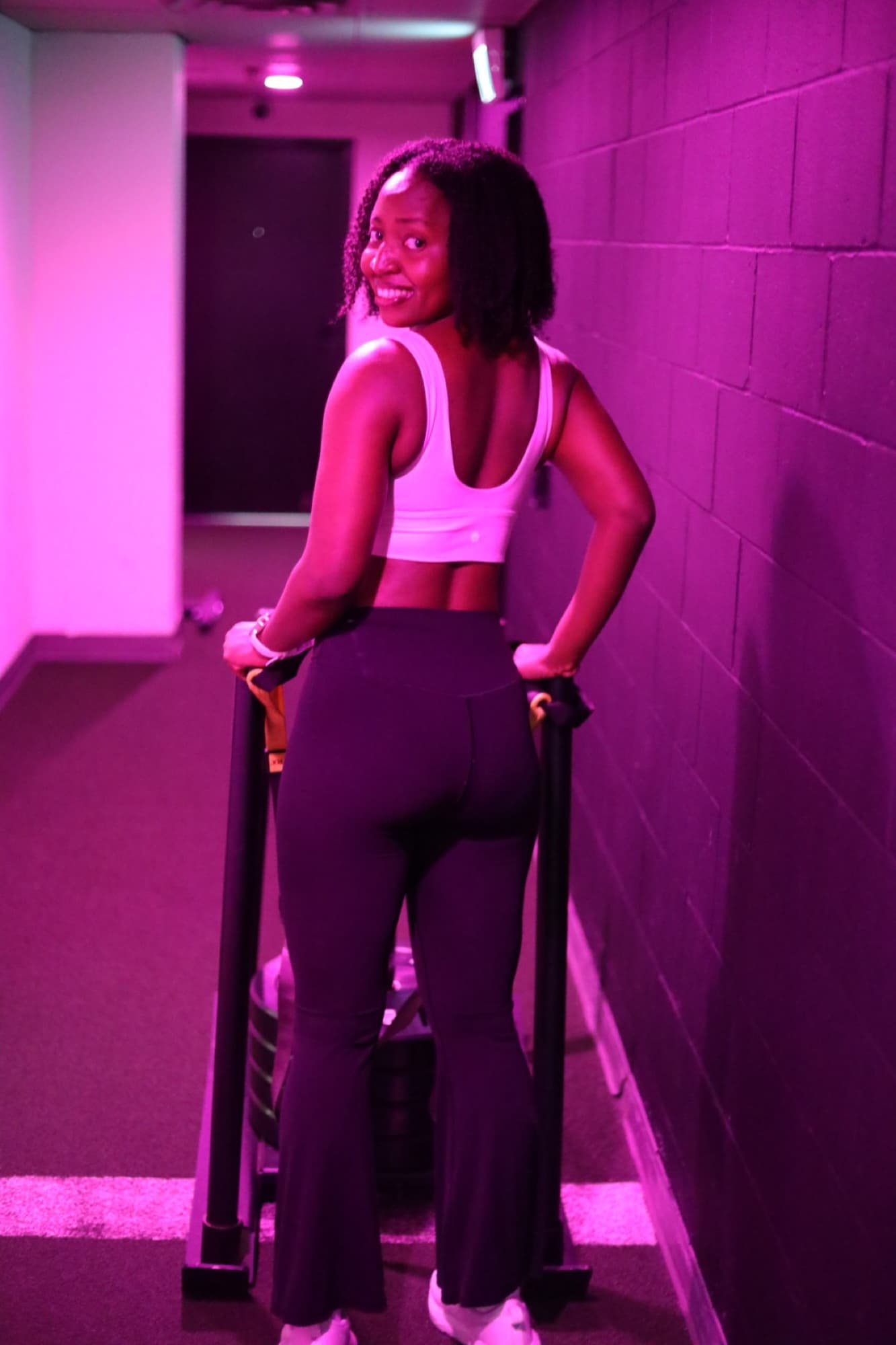 Gloria carrying loaded handles in the gym